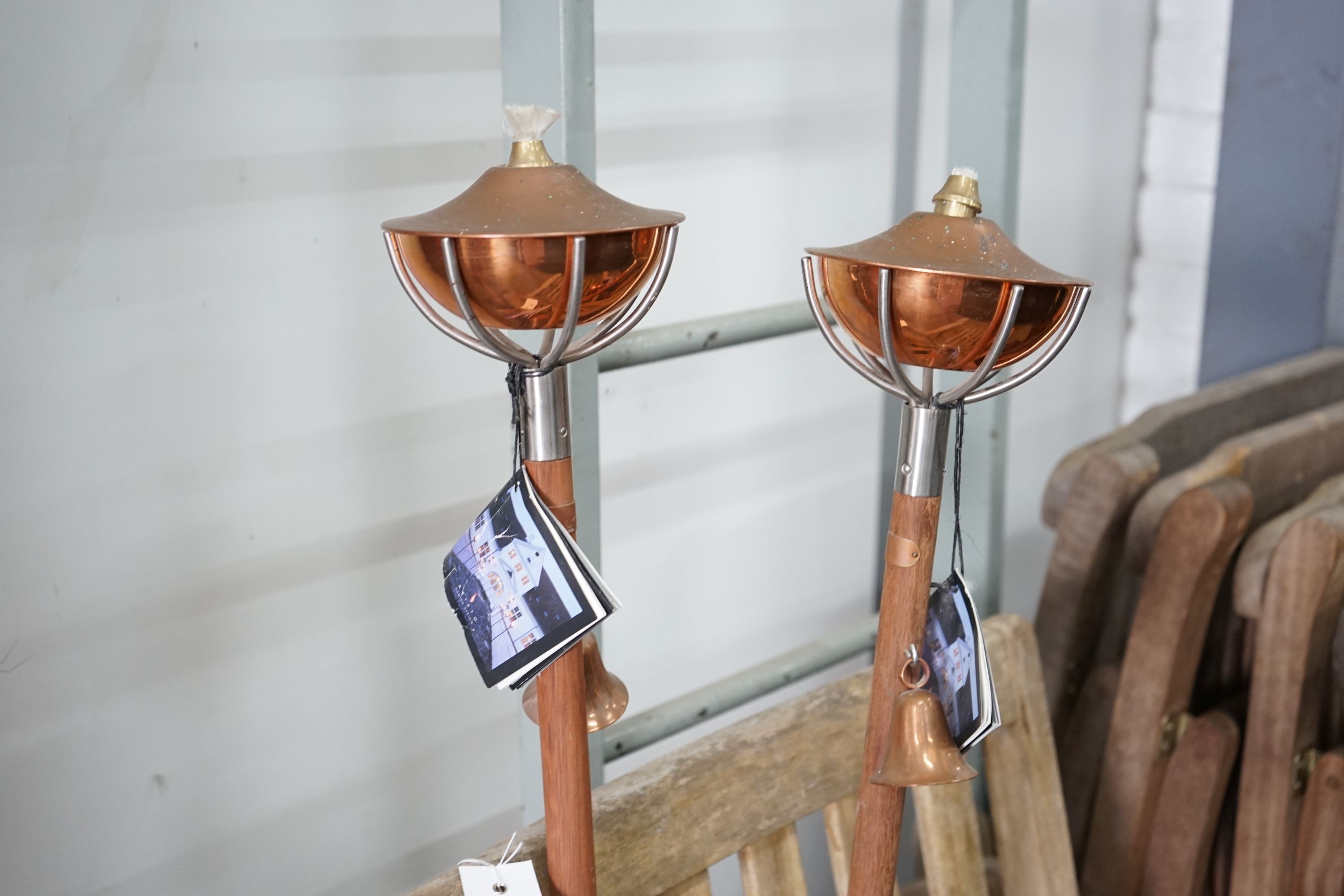 Four weathered teak folding garden chairs, a pair of teak reclining elbow chairs and a pair of Aristo garden oil lamps